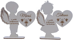 Dvojica drevených anjelov s gravírovanými menami a dátumom — pamiatka na prvé sväté prijímanie